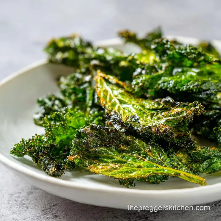 Pile of crispy kale chips cascading from a white bowl, highlighting their delicate, brittle texture and deep green hue.