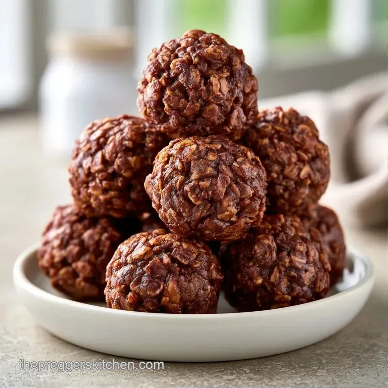 Small, dark brown chewy spheres stacked neatly on a slate board with a sprinkle of coconut flakes and a mint leaf.