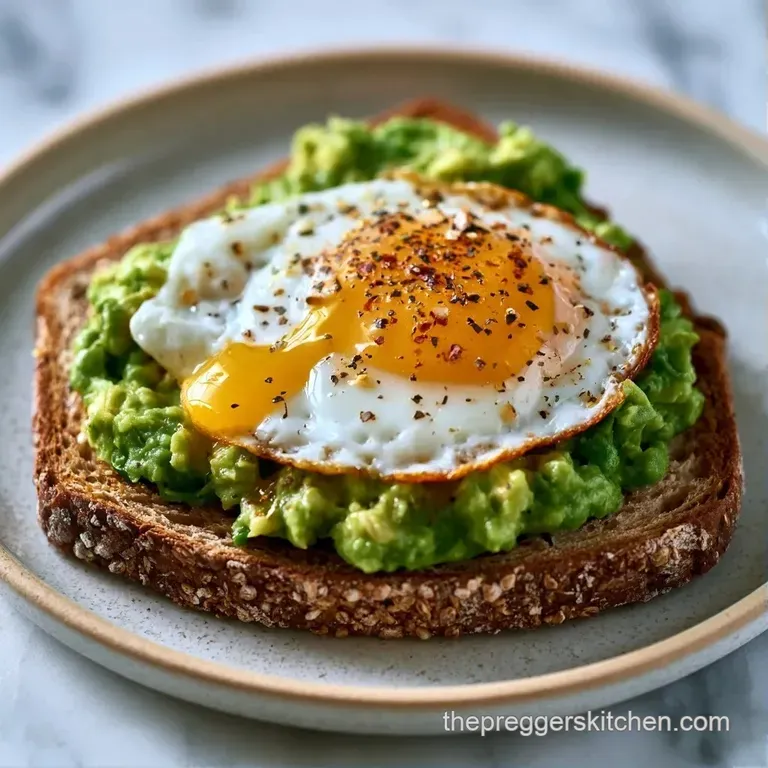 Vibrant green mashed avocado on crisp toast, plated on a white marble slab with fresh sprouts and a lemon wedge.