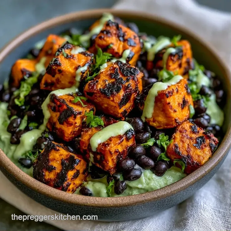 Vibrant bowl of roasted root vegetables, dark beans, and bright greens topped with a swirl of creamy white dressing.